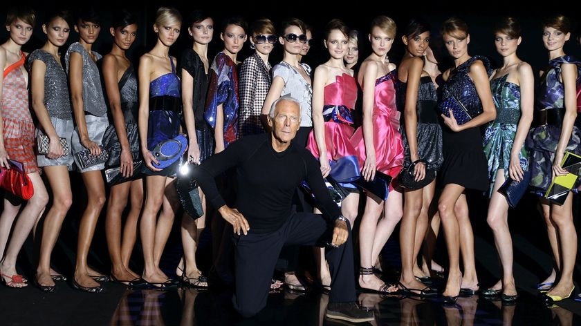 Italian designer Giorgio Armani poses with his models at the end of his Spring/Summer 2010 women's c