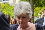People leave a court in Melbourne, with Frances Walshe looking downcast as she walks behind her lawyer.