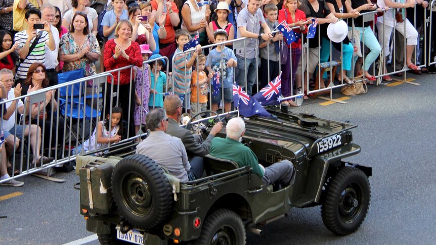 The crowd at the Brisbane Anzac Day parade watch the procession make its way through the CBD.
