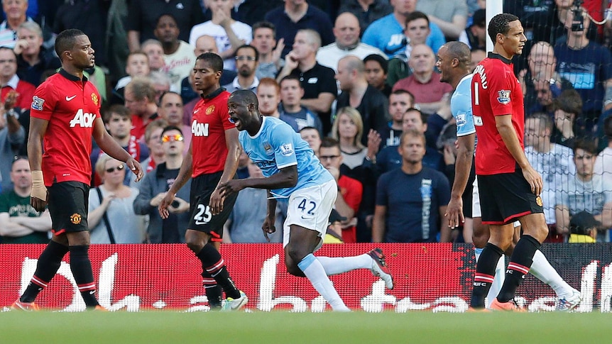 Manchester City's Yaya Toure (2nd R) celebrates after scoring against Manchester City.