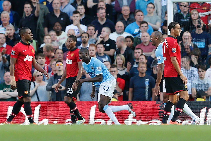 Manchester City's Yaya Toure (2nd R) celebrates after scoring against Manchester City.