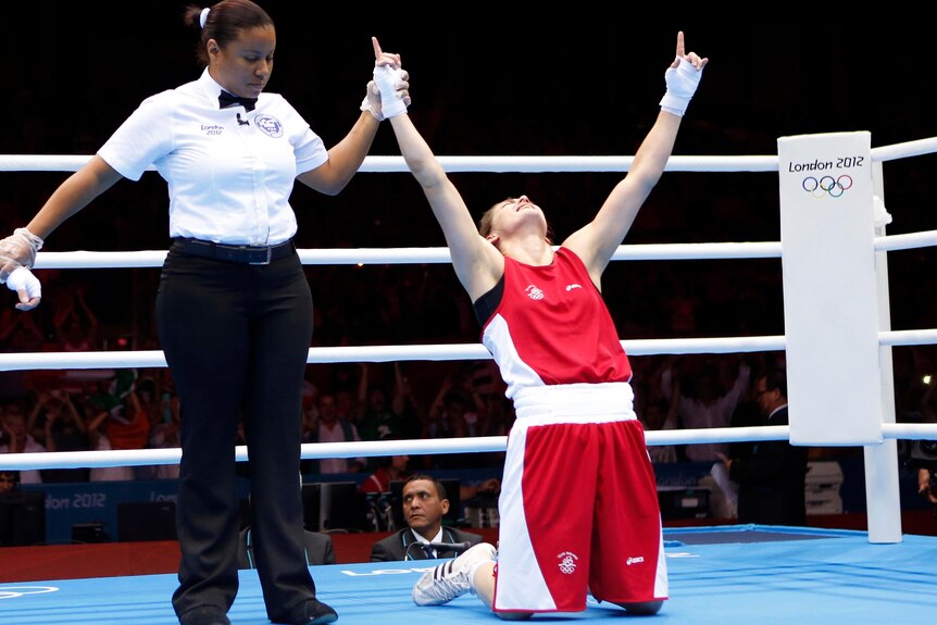 Katie Taylor drops to her knees after she wins the women's light (60kg) gold medal boxing match.