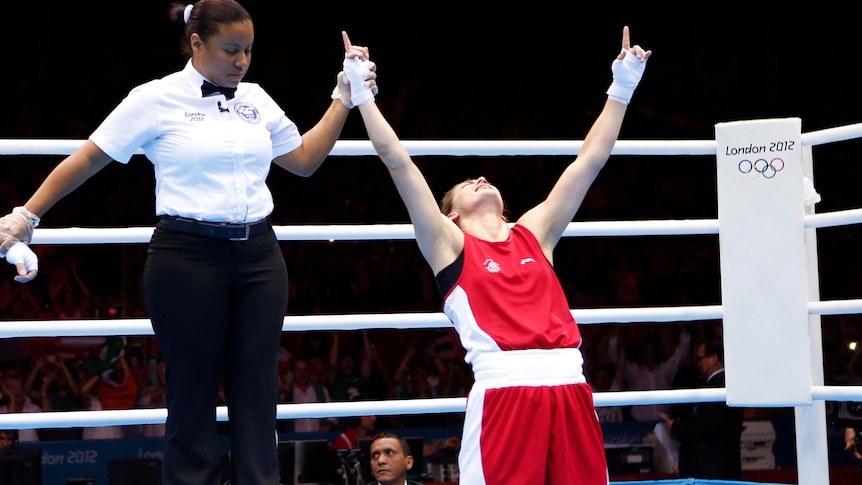 Katie Taylor drops to her knees after she wins the women's light (60kg) gold medal boxing match.