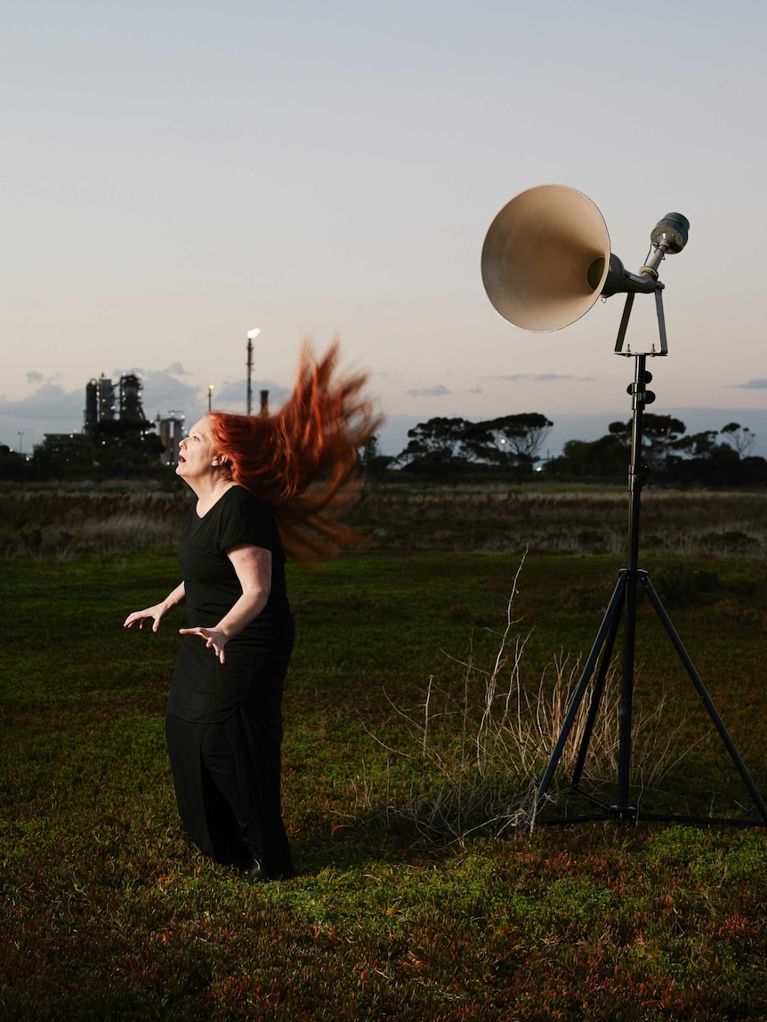 Vocalist Carolyn Connors in front of a speaker.