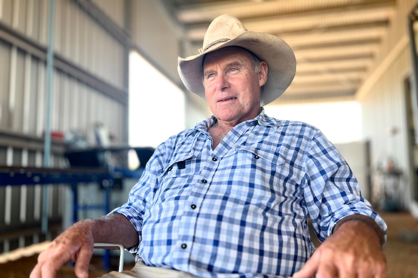 Farmer Bill Mott, wearing a hat, sits in a chair in a shed while being interviewed by Daniel Ziffer.