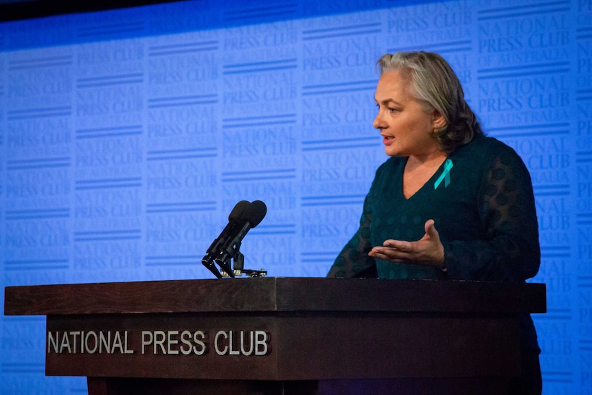 A woman speaking at the Press Club