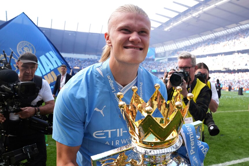 Erling Haaland gurns with the Premier League trophy
