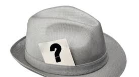 journalist hat, with a question mark card stuck in the brim