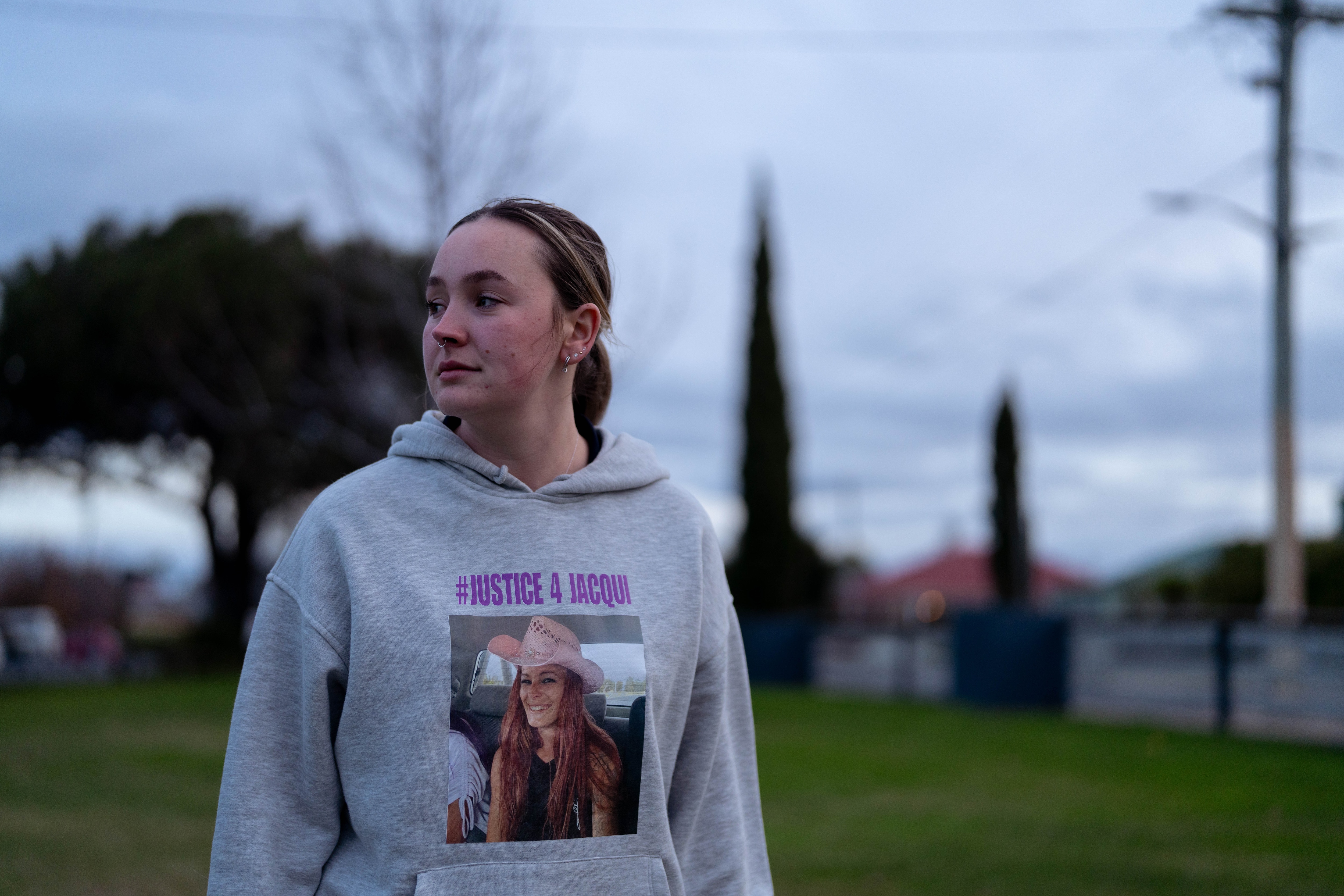Mujer vistiendo una sudadera con capucha gris en un parque