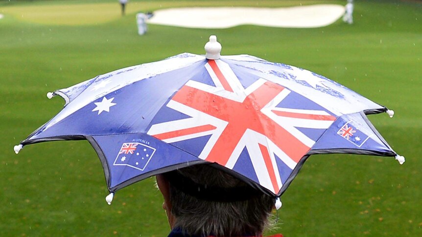 Fan watches play in the rain during the second round of the 77th Masters.