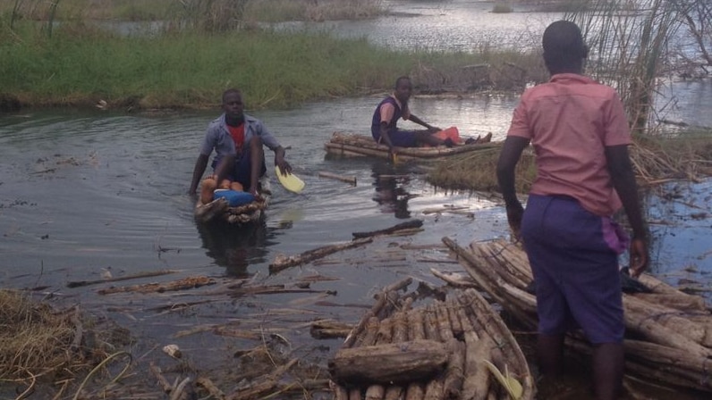 Kenyan children paddle across Lake Baringo on boats made of softwood branches tied together with nylon rope