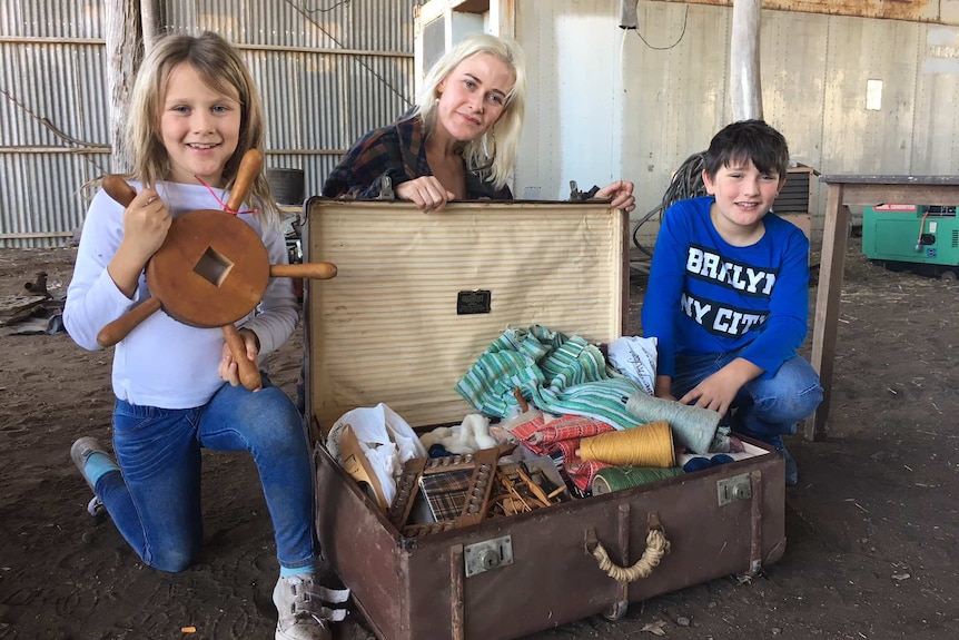 Antoinette Rowland (left), Claire Elliott and Orlando Rowland pose with a suitcase.