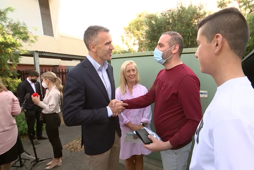 Syrian refugee Rateb Alkhalil shakes hands with Peter Malinauskas.