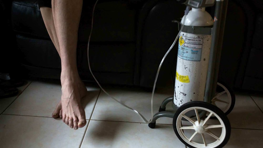 Sue Jensen's legs next to her oxygen bottle.