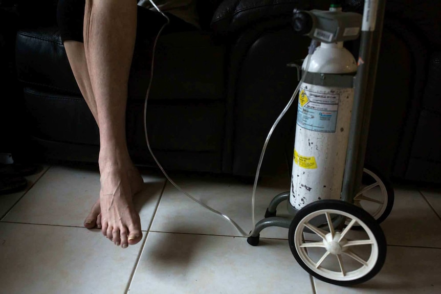 Sue Jensen's legs next to her oxygen bottle.