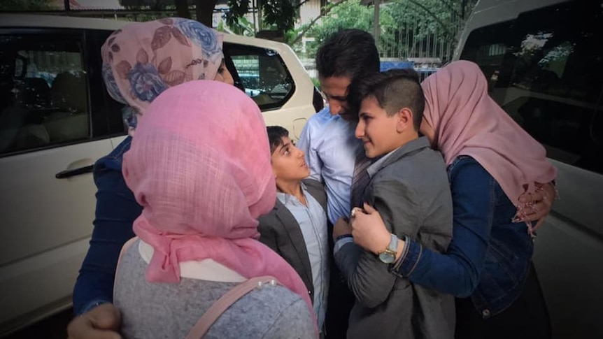 Abdullah Zalghanah embraces his wife and children.
