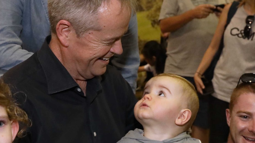 Labor leader Bill Shorten smiles at a baby.