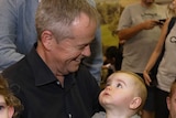 Labor leader Bill Shorten smiles at a baby.