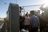Border authorities usher kids past at a border crossing.