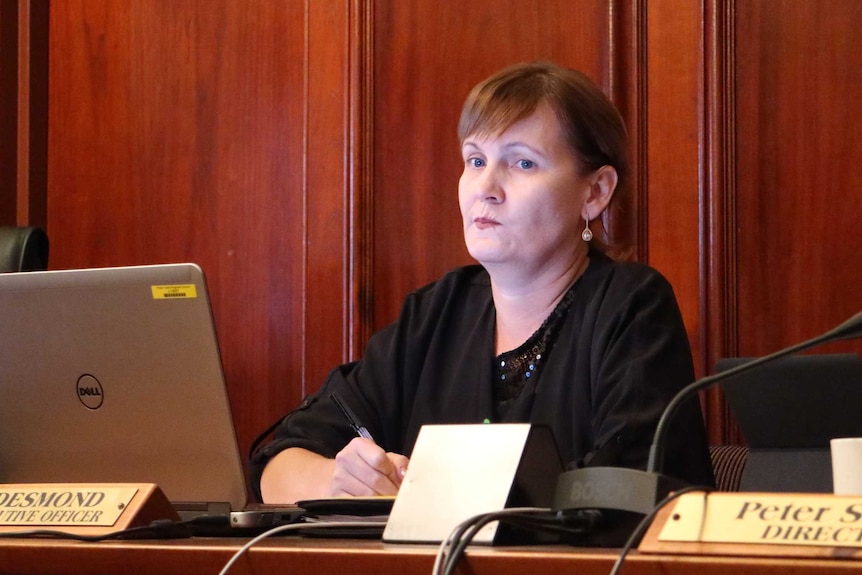 ceo lisa desmond pursing her lips while sitting in front of a laptop in council chambers