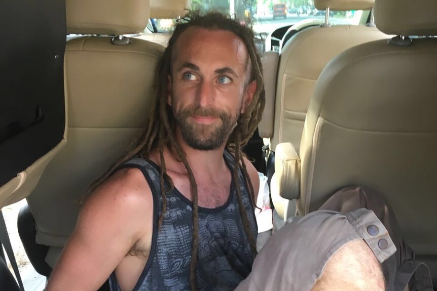 Bali policeman murder accused David James Taylor handcuffed in the back of a police car.