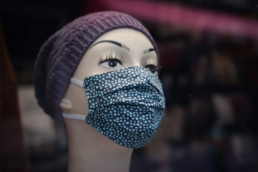 A face mask is displayed on a shop mannequin's head