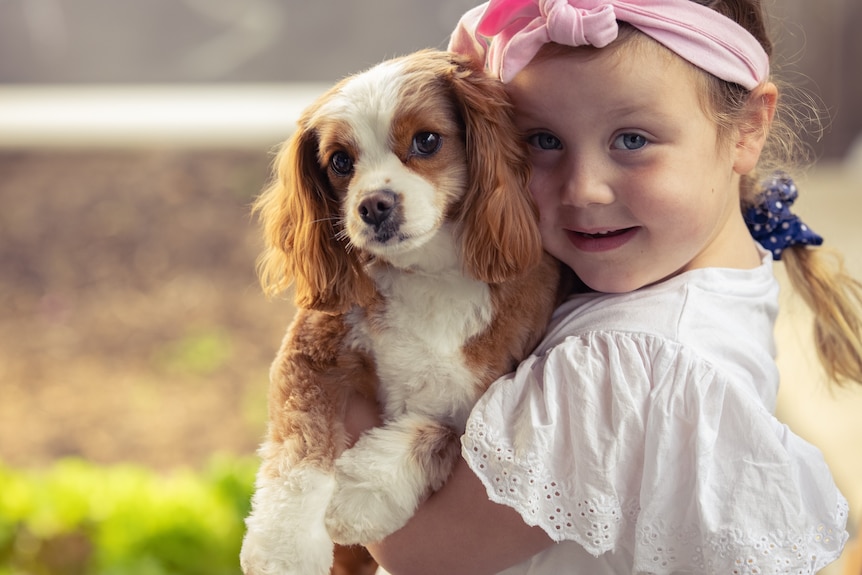 Five year old Tilly hugs her dog. 