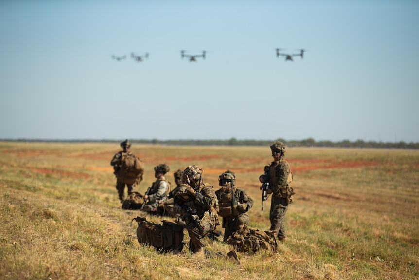 a group of camouflaged soldiers in short grass