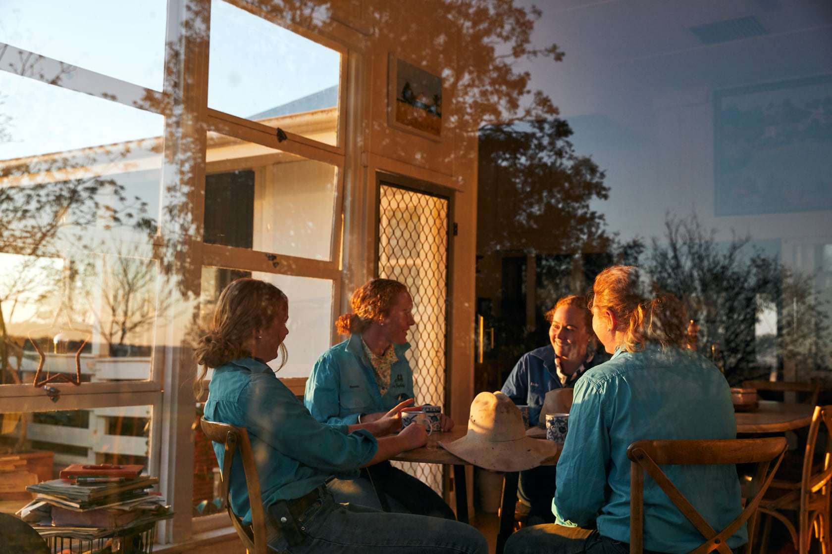 The four daughters inside their home, sitting at the kitchen table talking