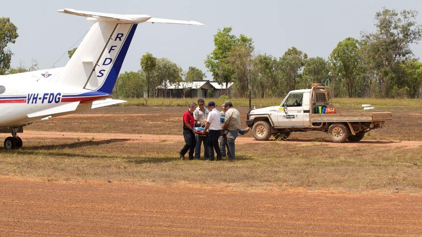 Royal Flying Doctor Service staff take a patient onto a plan in western Qld.