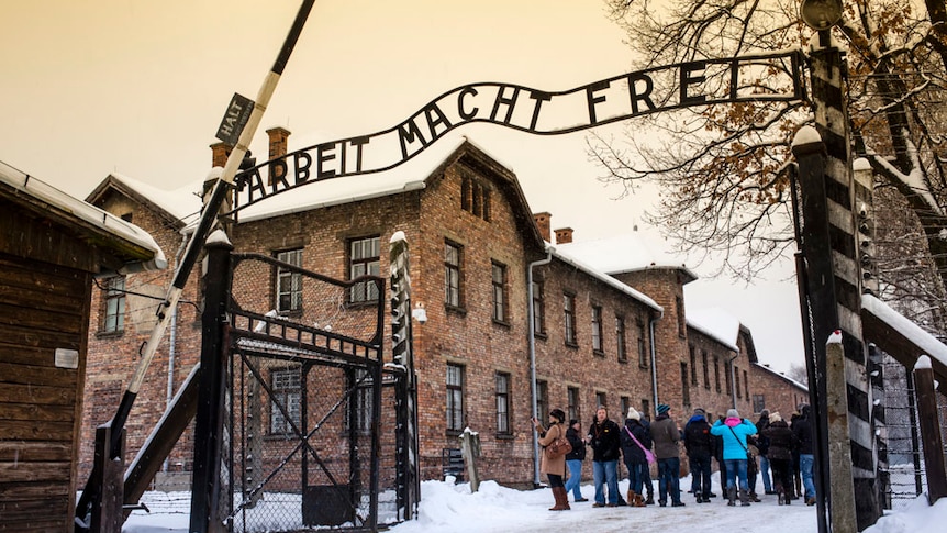 Tourists under Arbeit macht frei sign at Auschwitz Concentration Camp