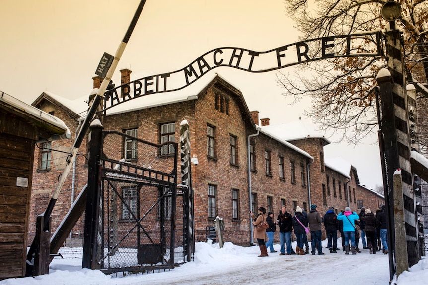 Tourists under Arbeit macht frei sign at Auschwitz Concentration Camp