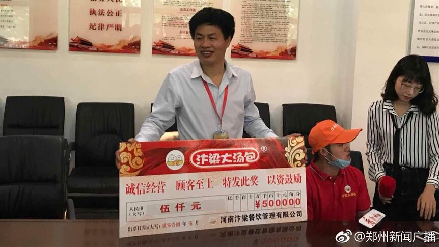 Liuzhu He is awarded a big 5000 yuan cheque.