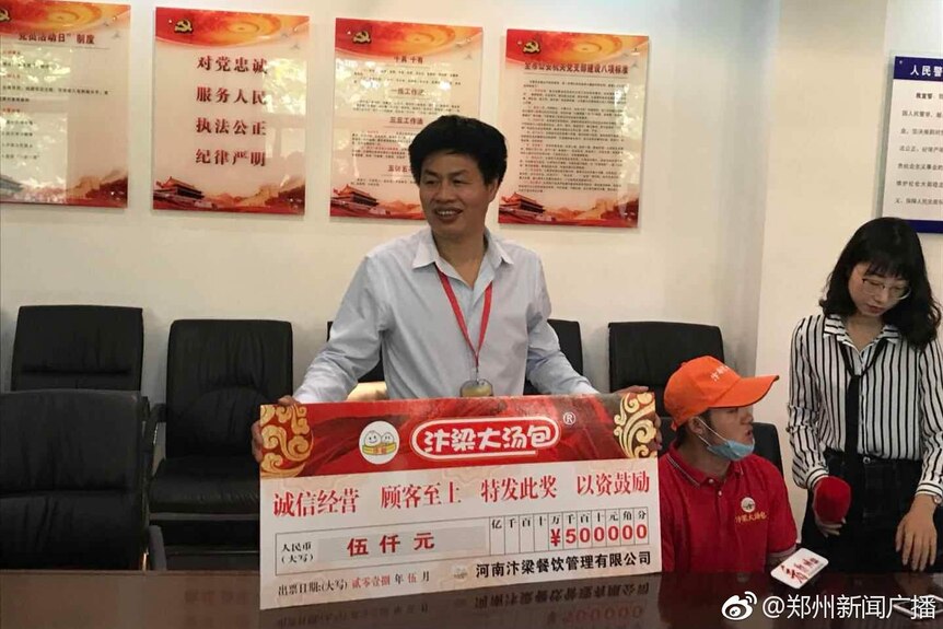 Liuzhu He is awarded a big 5000 yuan cheque.