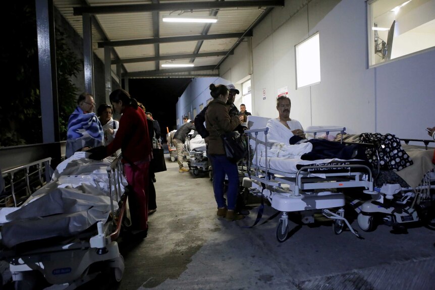 Patients sit on stretchers and speak to family members after the earthquake in Mexico.
