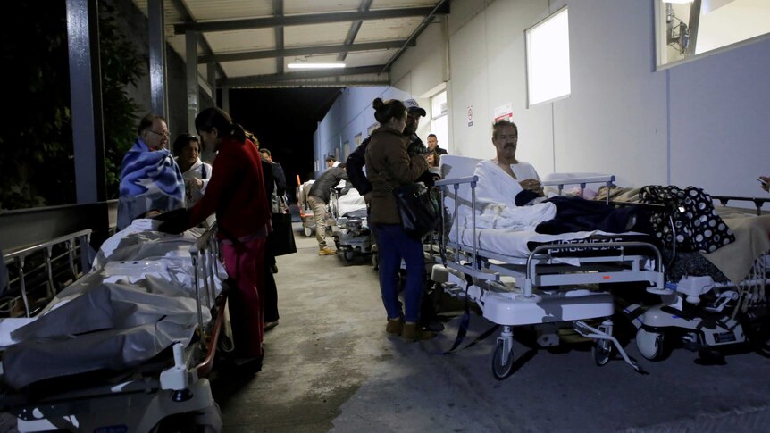 Patients sit on stretchers and speak to family members after the earthquake in Mexico.