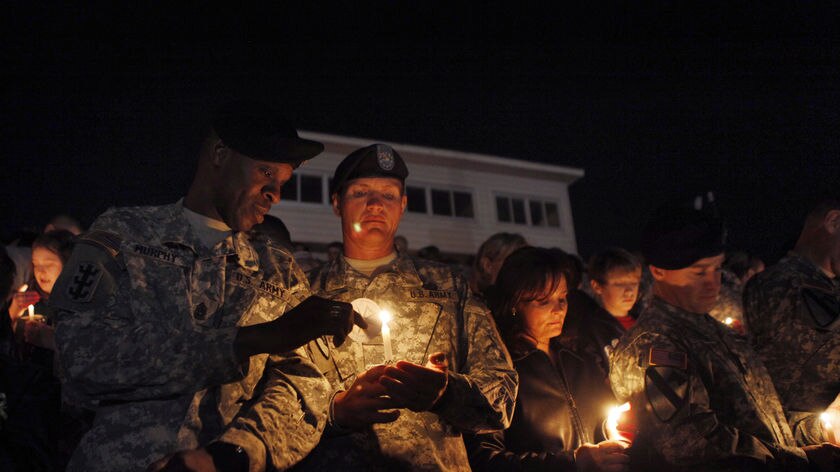 Soldiers light candles during a vigil at Hood Stadium on the Fort Hood army post.