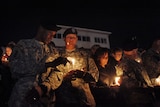 Soldiers light candles during a vigil at Hood Stadium on the Fort Hood army post.