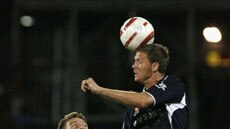 Geoffrey Claeys (r) of the Melbourne Victory gets his head to the ball, while Damien Mori looks to