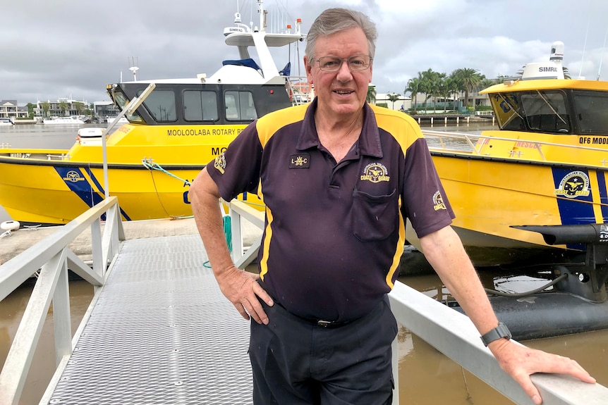 A man leans against the railing of the ramp to the Mooloolaba Coast Guard vessels.