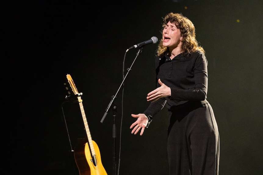 Aldous Harding sings with her whole body, dressed in black on stage at the Sydney Opera House concert all