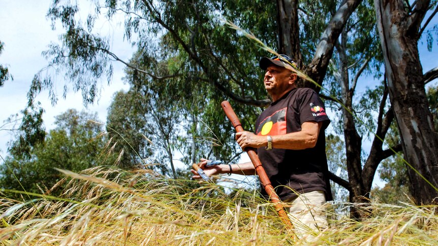 Aboriginal Indigenous elder Uncle Trevor Gallagher stands in Darebin Parklands in inner city Melbourne.