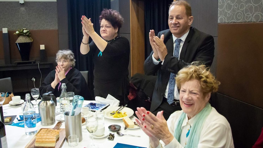 Jill Emberson's family applaud her speech at the National Press Club.