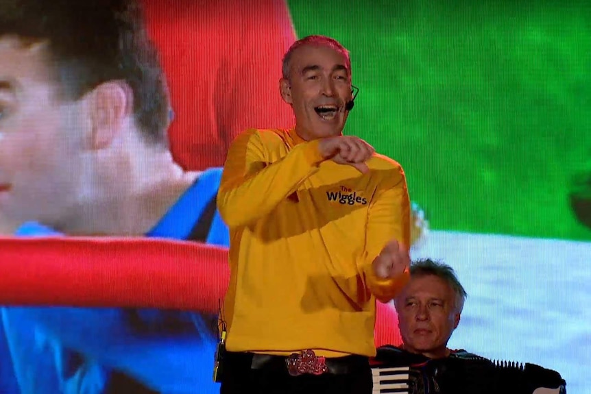 Greg Page wearing a yellow Wiggles costume performing on stage