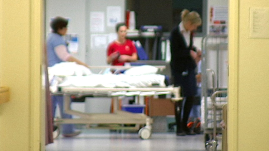 Three women stand near a hospital guerney