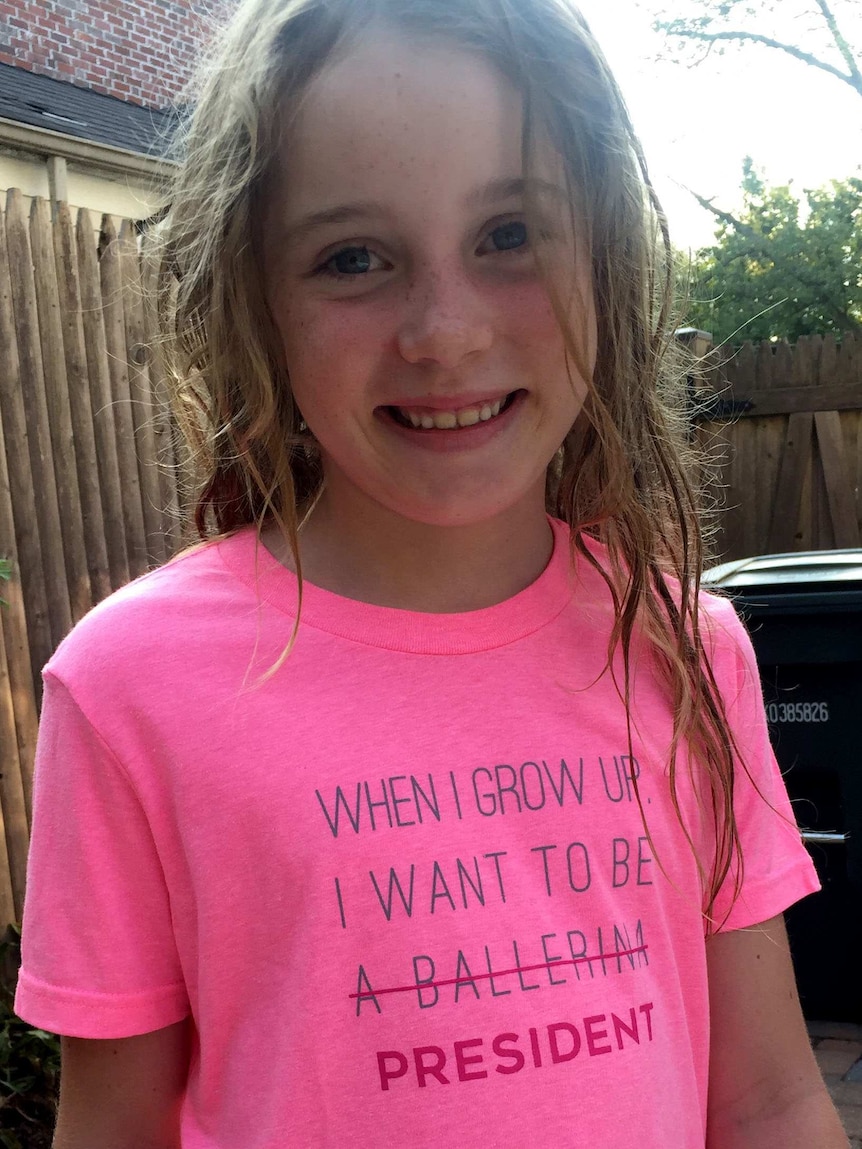 Eight-year-old Pearl wearing a shirt that says "When I grow up I want to be (a ballerina, words crossed out) PRESIDENT".