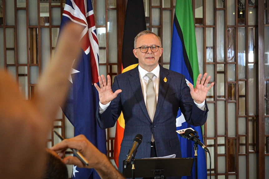 Anthony Albanese at a lecture with his hands raised 