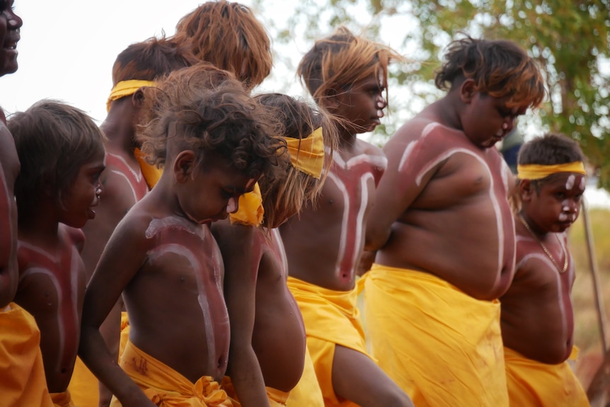 Young dancers dressed in yellow in a traditional performance. 