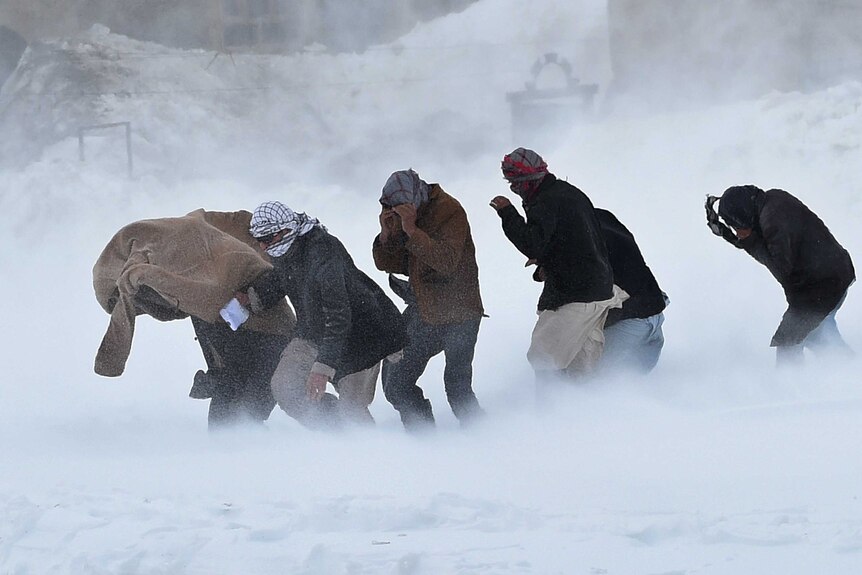 Afghan survivors of an avalanche run to get relief goods