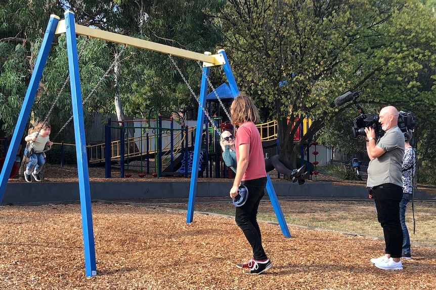 Kate Miller-Heidke and her son are recorded riding the swings
